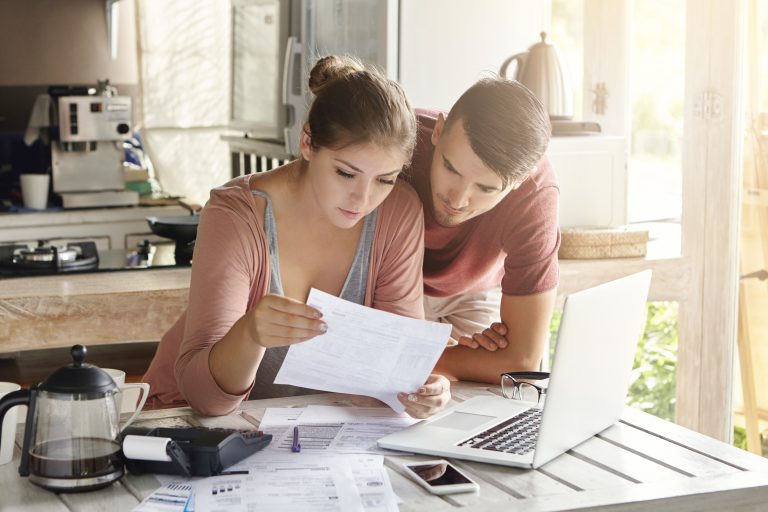 young-couple-managing-finances-reviewing-their-bank-accounts-using-laptop-computer-calculator-modern-kitchen-woman-man-doing-paperwork-together-768x512 Ignoring Your Credit History